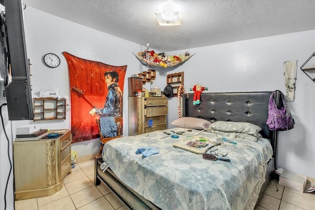 bedroom with light tile patterned floors and a textured ceiling