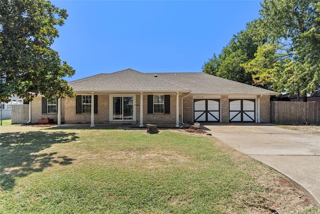 single story home with a porch, a garage, and a front lawn