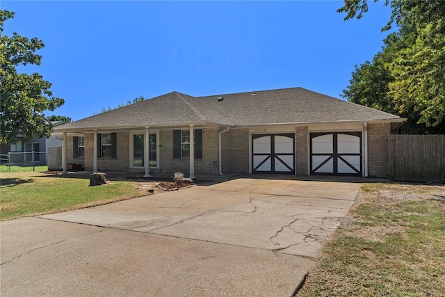 ranch-style house featuring a porch, a garage, and a front lawn