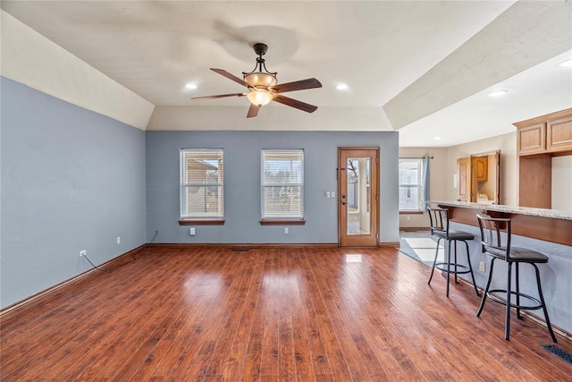 unfurnished living room with ceiling fan, dark hardwood / wood-style flooring, and a wealth of natural light