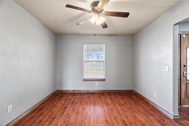 spare room with ceiling fan and dark hardwood / wood-style flooring