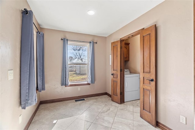 clothes washing area with cabinets, washer / dryer, and light tile patterned floors