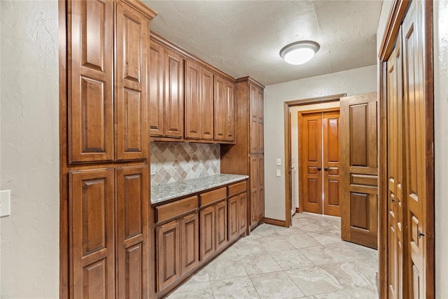 kitchen featuring light stone counters and tasteful backsplash