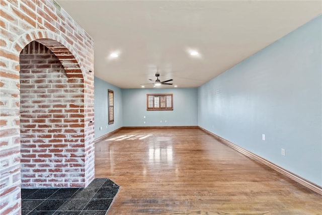 unfurnished living room with wood-type flooring and ceiling fan