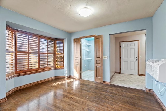 unfurnished room featuring a textured ceiling and light hardwood / wood-style flooring