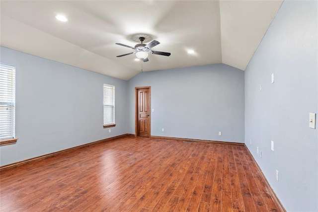 empty room featuring hardwood / wood-style flooring, ceiling fan, and lofted ceiling