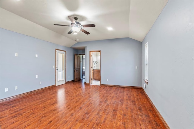 unfurnished bedroom featuring hardwood / wood-style flooring, ceiling fan, connected bathroom, and vaulted ceiling