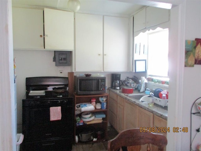 kitchen with white cabinets, light brown cabinets, sink, and black range with gas cooktop