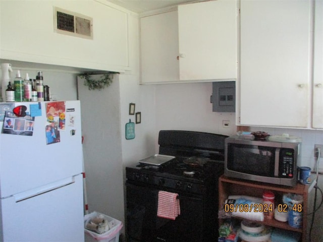 kitchen with electric panel, black gas stove, white cabinets, and white refrigerator