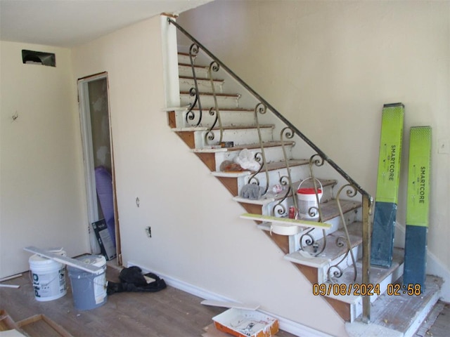 staircase with wood-type flooring