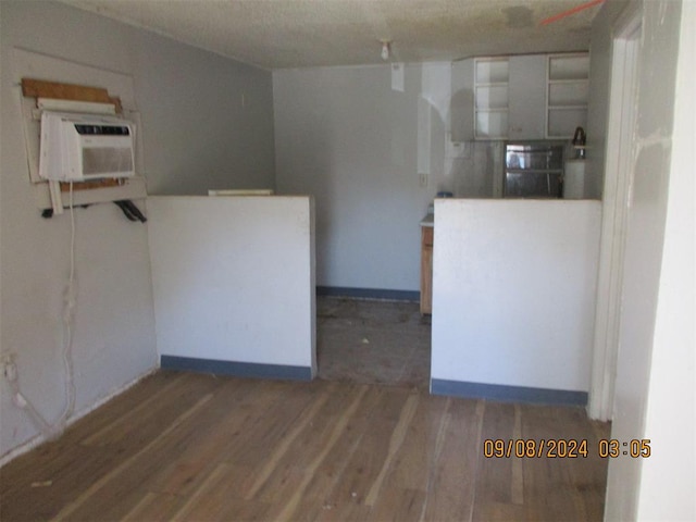 interior space featuring dark wood-type flooring and a wall unit AC