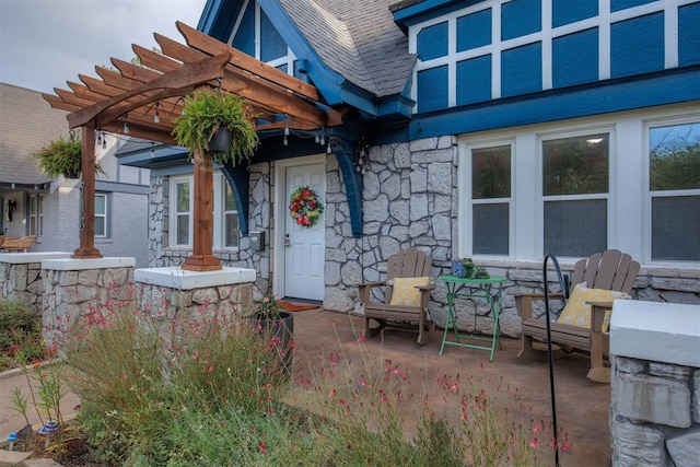 property entrance featuring a pergola and a patio area