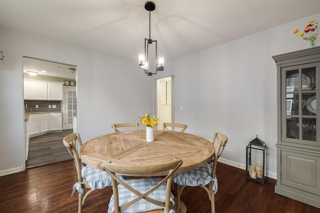 dining room featuring dark hardwood / wood-style flooring, sink, and a chandelier