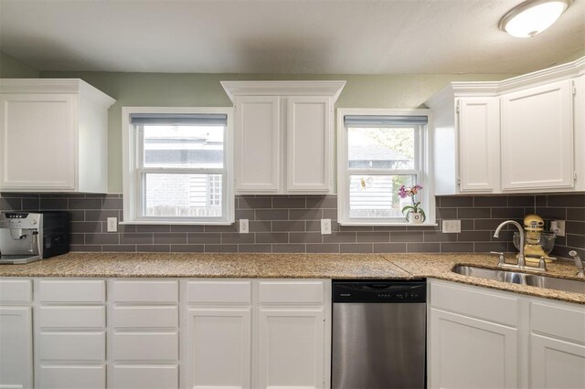 kitchen with decorative backsplash, sink, white cabinets, and stainless steel dishwasher