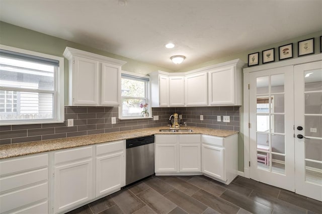 kitchen featuring white cabinets, backsplash, stainless steel dishwasher, and sink