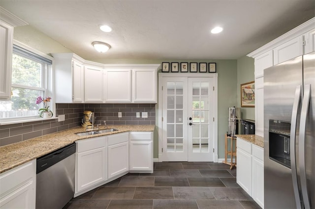 kitchen featuring french doors, stainless steel appliances, white cabinetry, and sink