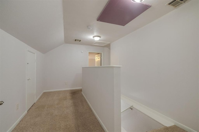 bonus room with light colored carpet and vaulted ceiling