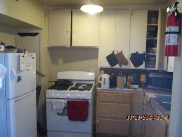 kitchen featuring white cabinetry and white appliances