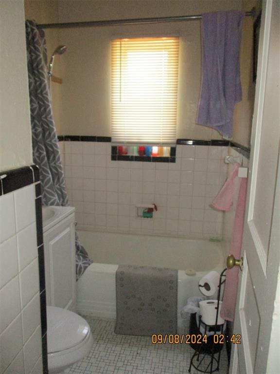 full bathroom with vanity, tile patterned floors, toilet, tile walls, and shower / tub combo with curtain