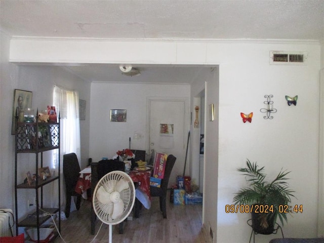 dining area with ornamental molding and hardwood / wood-style flooring