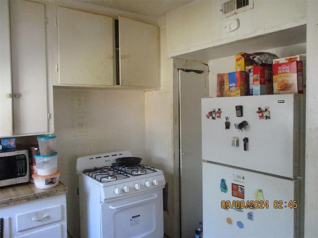 kitchen with white cabinetry and white appliances