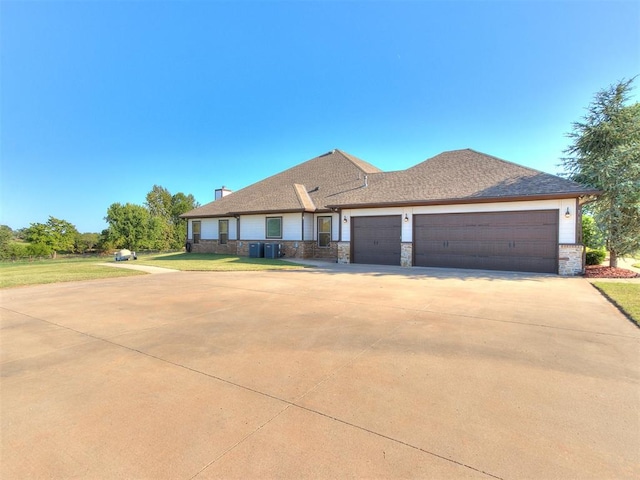 view of front of home featuring central air condition unit, a front yard, and a garage