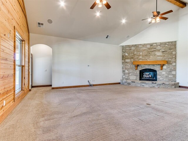 unfurnished living room featuring ceiling fan, a fireplace, high vaulted ceiling, and light carpet