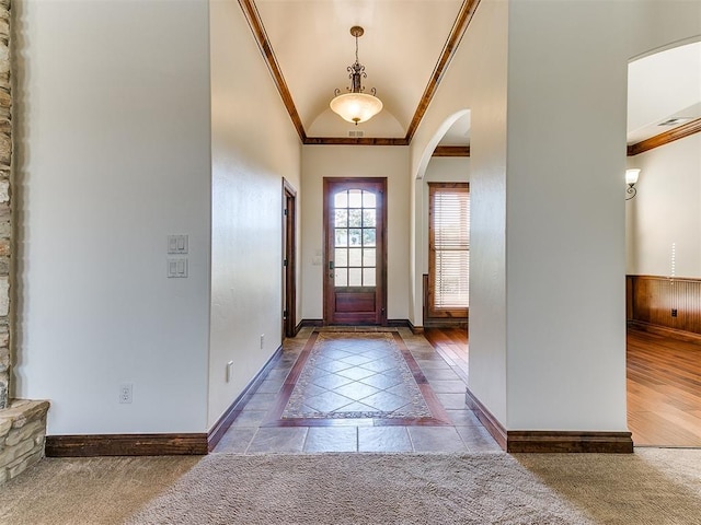 entrance foyer featuring crown molding, dark wood-type flooring, and vaulted ceiling