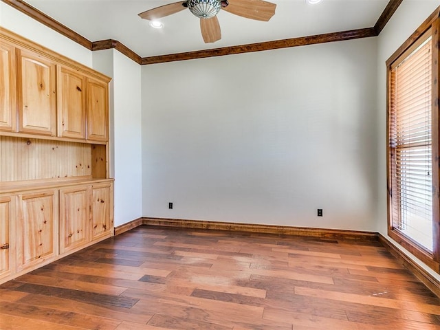 unfurnished room with ceiling fan, dark wood-type flooring, and ornamental molding