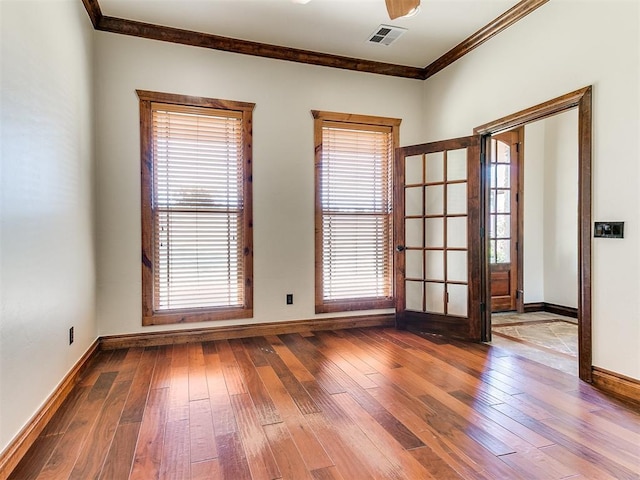 spare room featuring hardwood / wood-style floors, plenty of natural light, and crown molding