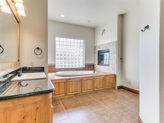 bathroom with tile patterned flooring, a bathtub, and vanity