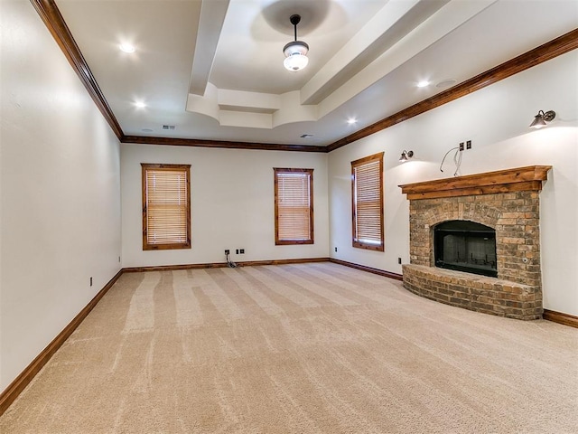 unfurnished living room with a raised ceiling, light carpet, a fireplace, and ornamental molding