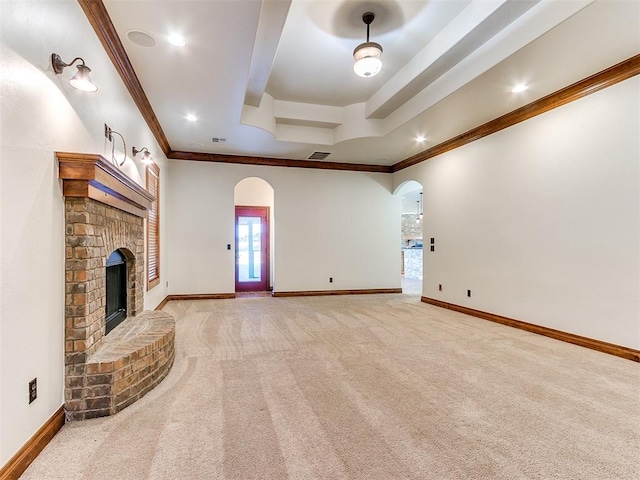 unfurnished living room with light colored carpet, a brick fireplace, and ornamental molding