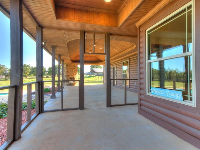 unfurnished sunroom featuring a healthy amount of sunlight and wood ceiling