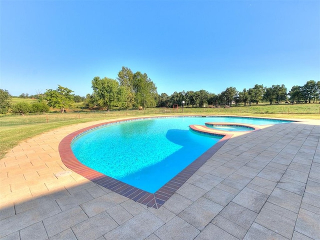 view of swimming pool with a lawn, a patio area, and an in ground hot tub