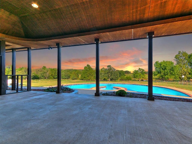 pool at dusk with a patio