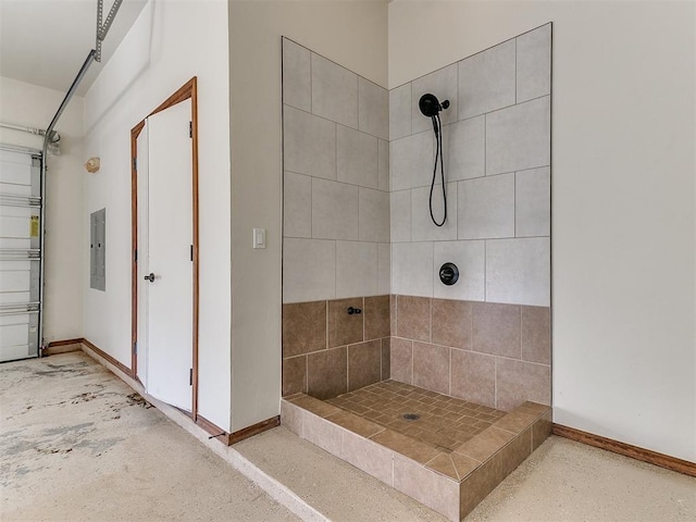 bathroom featuring a tile shower and electric panel