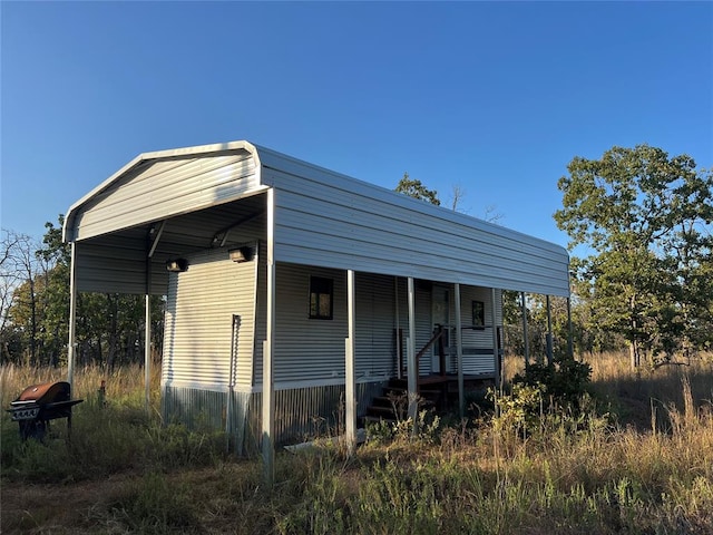 view of outbuilding with covered porch and a carport