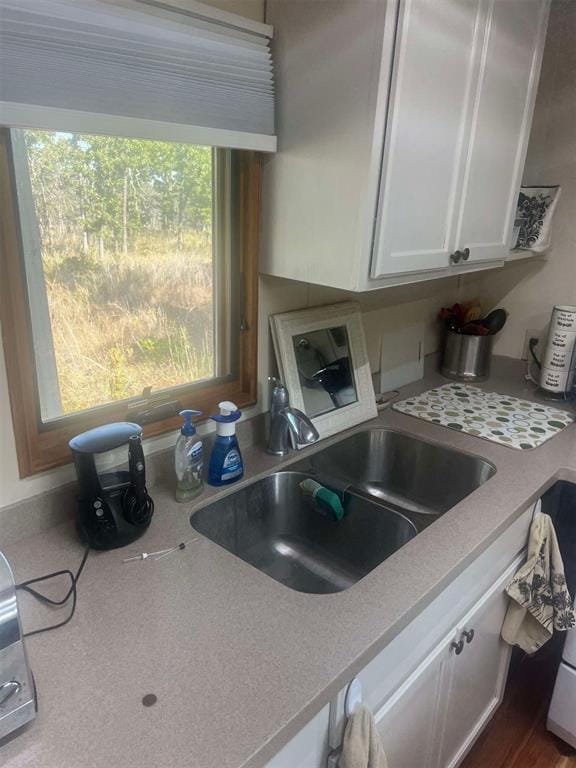 kitchen featuring white cabinetry and sink