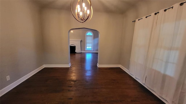 hall with dark wood-type flooring and an inviting chandelier