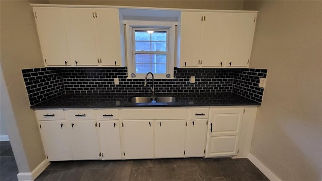 kitchen with dark hardwood / wood-style flooring, backsplash, white cabinetry, and sink