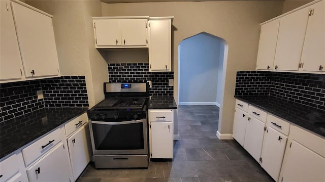 kitchen featuring tasteful backsplash, white cabinets, dark stone counters, and stainless steel gas range