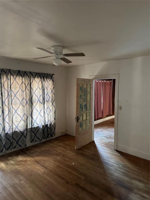 spare room featuring ceiling fan and dark wood-type flooring