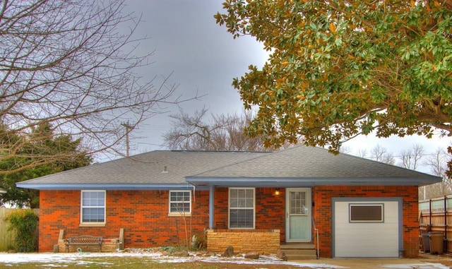 ranch-style home with entry steps, a shingled roof, and brick siding