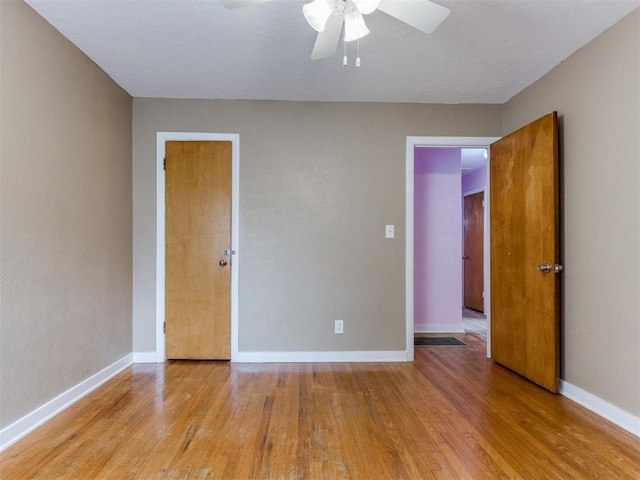 unfurnished bedroom featuring light wood-style floors, baseboards, and a ceiling fan