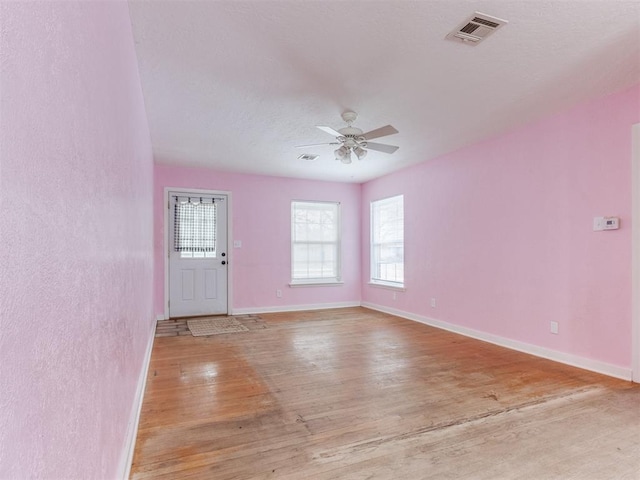 interior space with visible vents, ceiling fan, light wood-style flooring, and baseboards