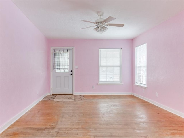 interior space with light wood-style floors, ceiling fan, and baseboards