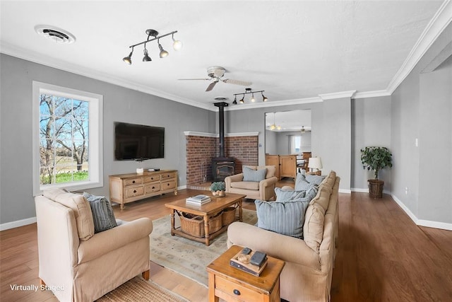 24484 E 990th Rd, Weatherford, OK 73096 - living room featuring ceiling fan, light hardwood / wood-style floors, a wood stove, and ornamental molding