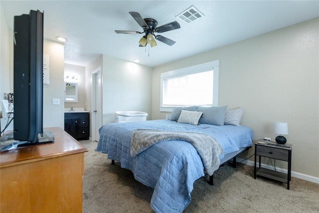 bedroom with carpet flooring, ensuite bathroom, ceiling fan, and sink