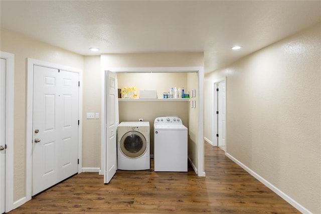 laundry area with washing machine and dryer and dark wood-type flooring